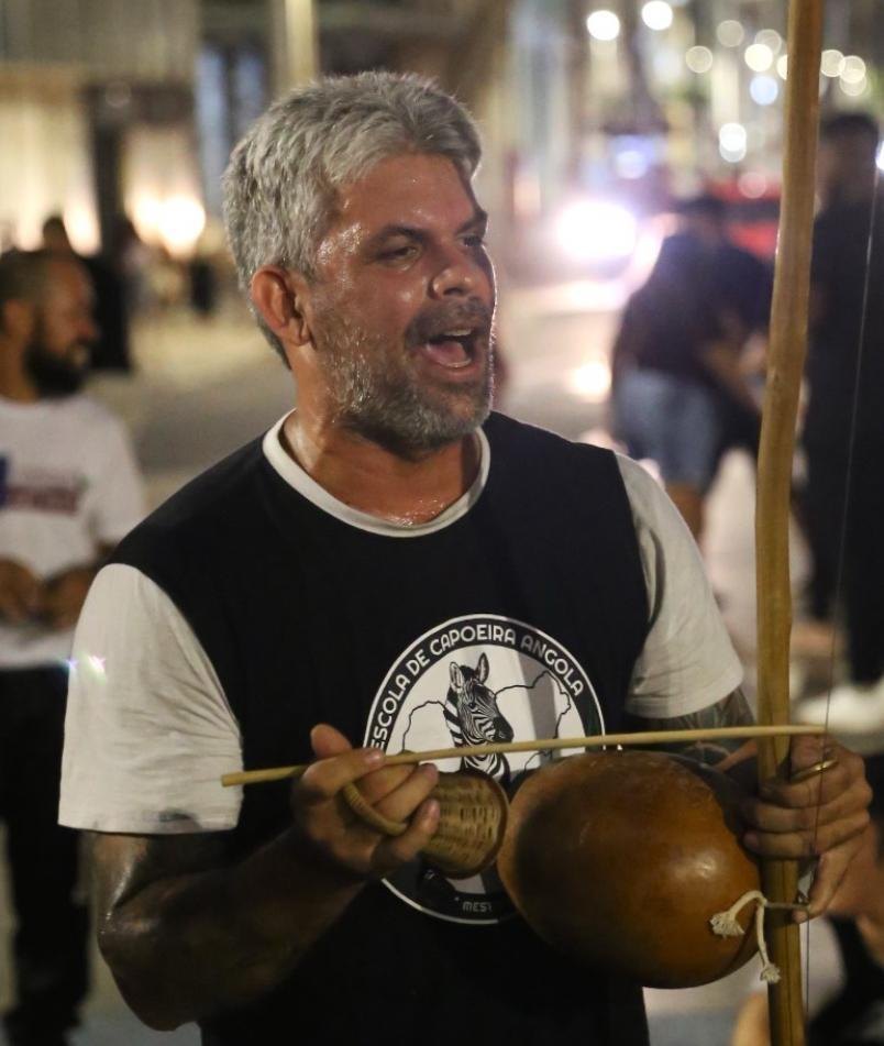 Cantando e tocando berimbau na roda de rua